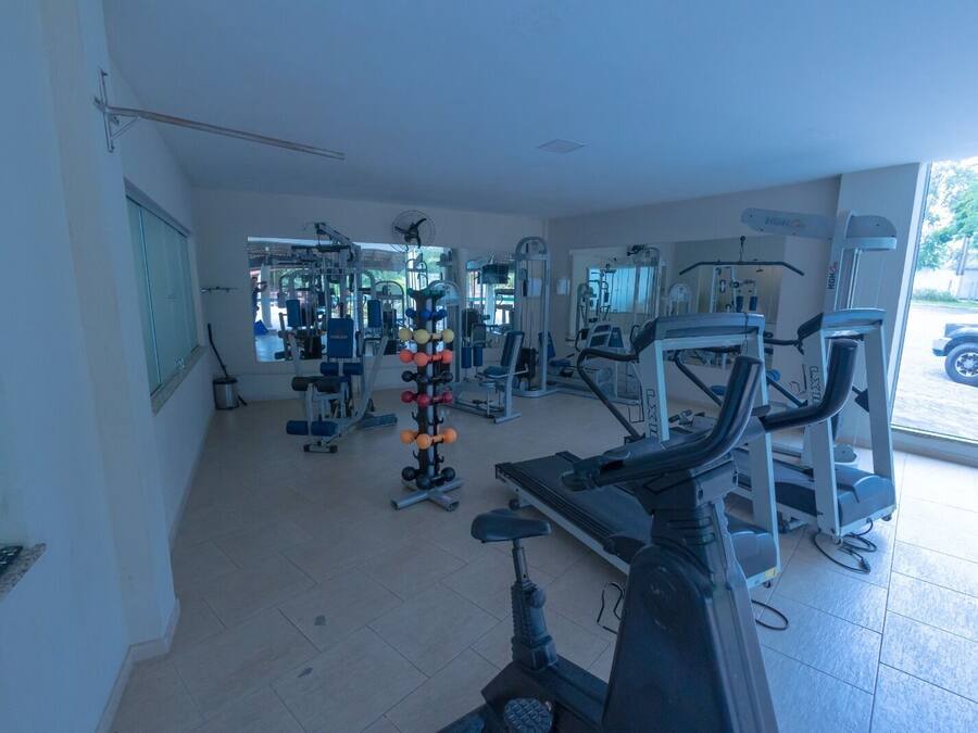 Un gimnasio con diverso equipo de ejercicio, incluyendo cintas de correr y máquinas de pesas.