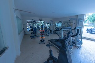 Uma academia com diversos equipamentos de exercícios, incluindo esteiras e aparelhos de musculação.