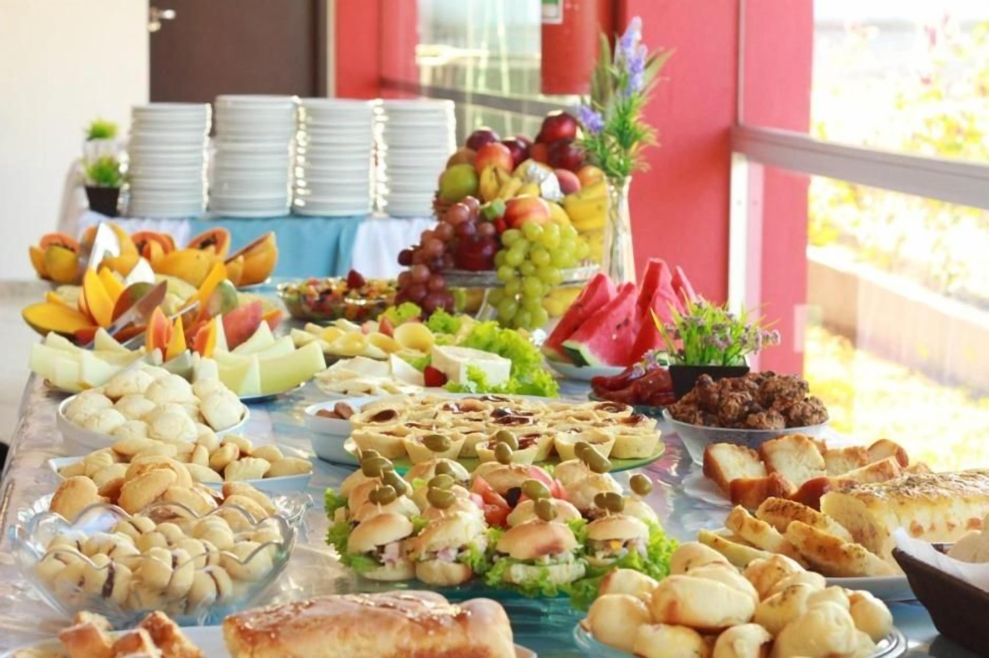A buffet table with various food items and a fruit display.