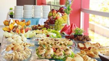 A buffet table with various food items and a fruit display.