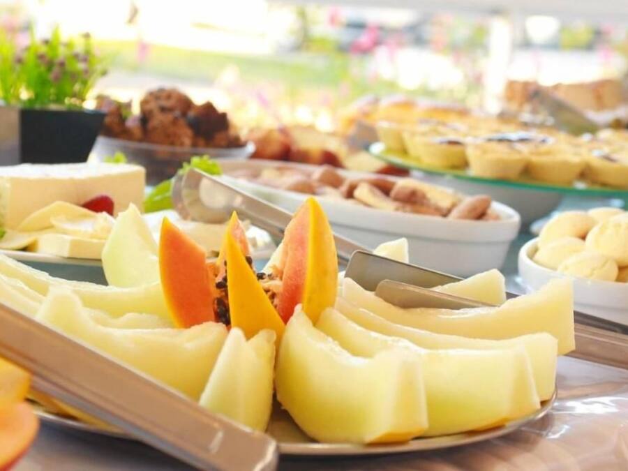 Een buffet met diverse gerechten, waaronder fruit en gebak.