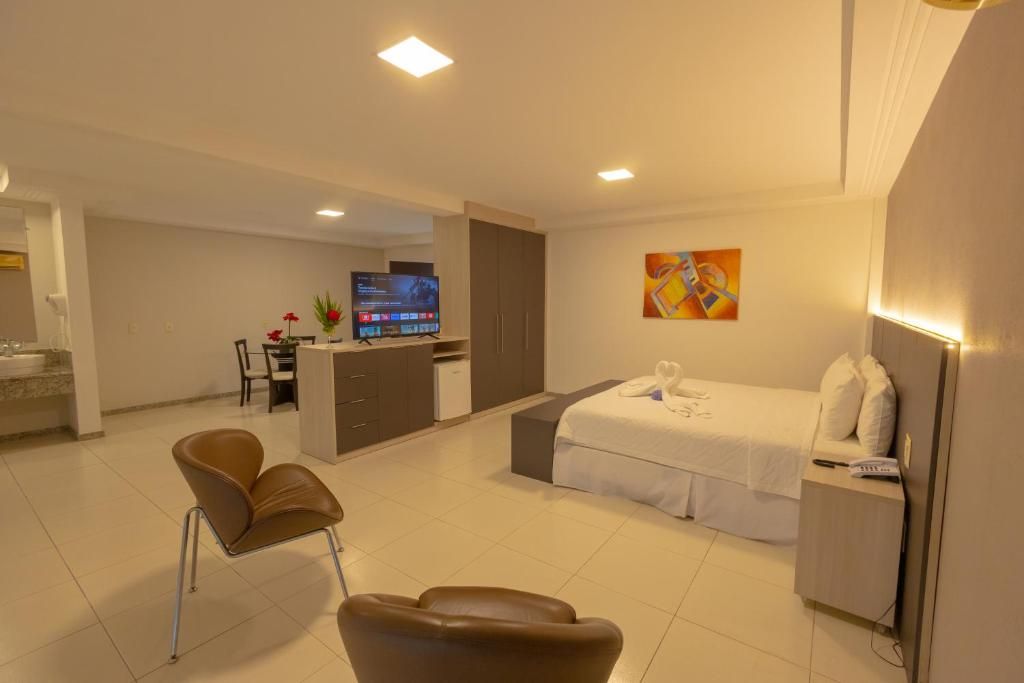 Una habitación de hotel con una cama, una mesita de noche y un televisor al fondo.