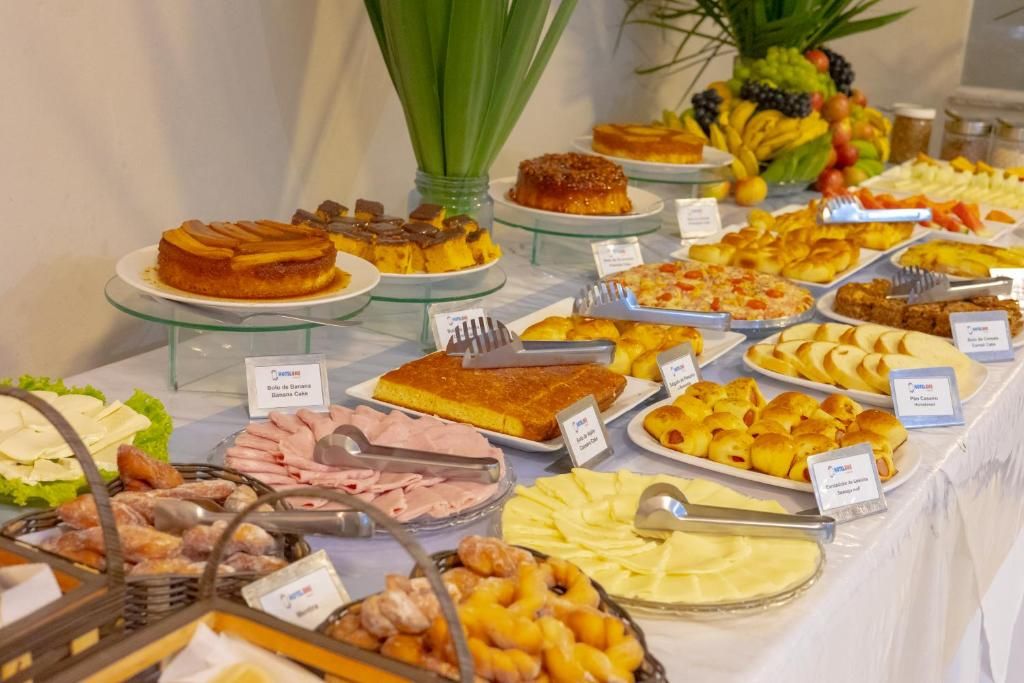 Un bufé con diversos alimentos, como pasteles, panes y frutas.