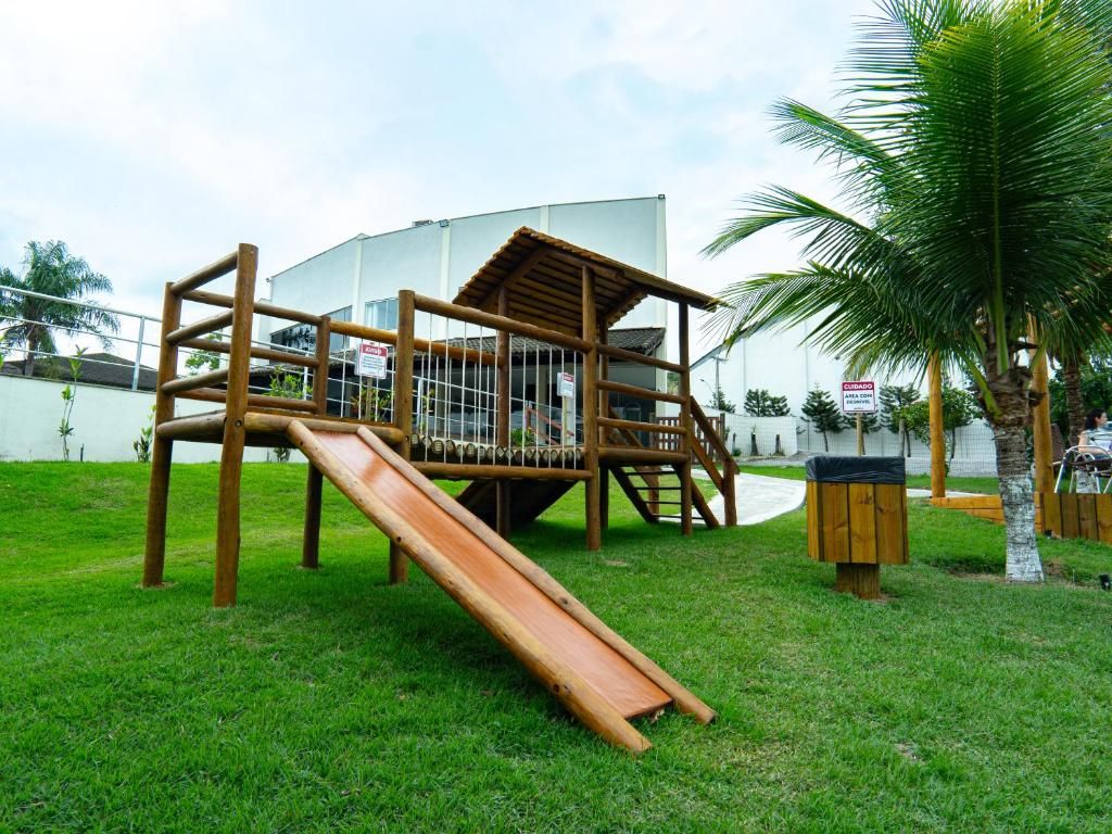 Un parque infantil con un tobogán de madera y una estructura para escalar.
