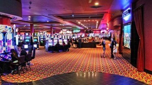 Un casino con varias máquinas de juego y una alfombra estampada.