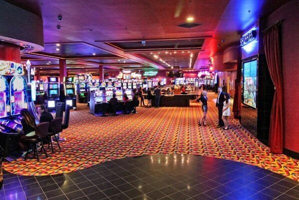 Un casino con varias máquinas de juego y una alfombra estampada.