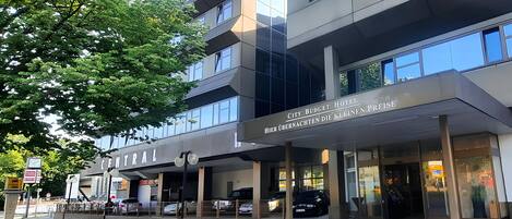 Un hotel moderno con un letrero que dice "City Budget Hotel" y "Hier übernachten die kleinen Preise".