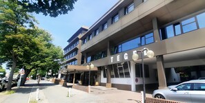 Un edificio moderno con un letrero que dice "TEG" y un acceso cubierto.
