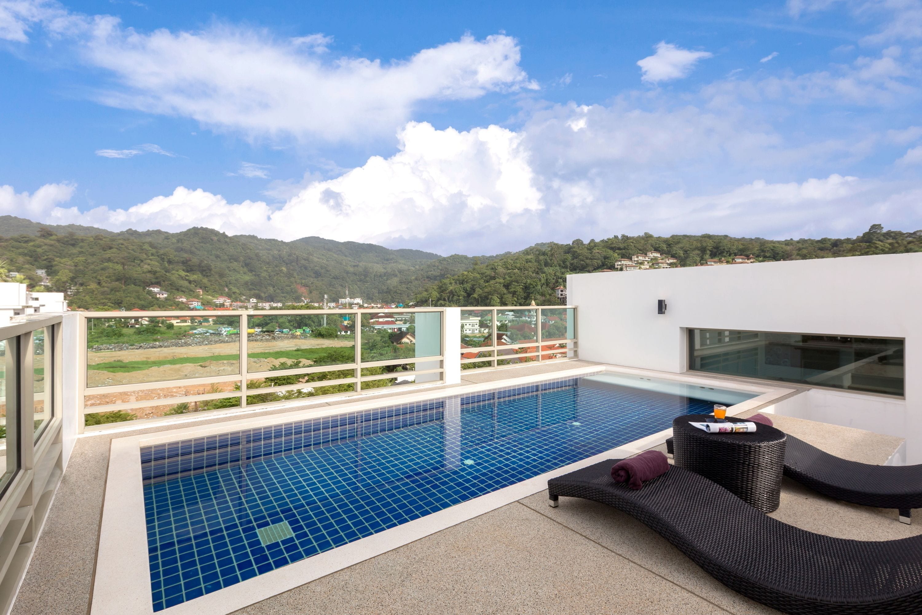 A rooftop pool with a clear view of the surrounding landscape and mountains.