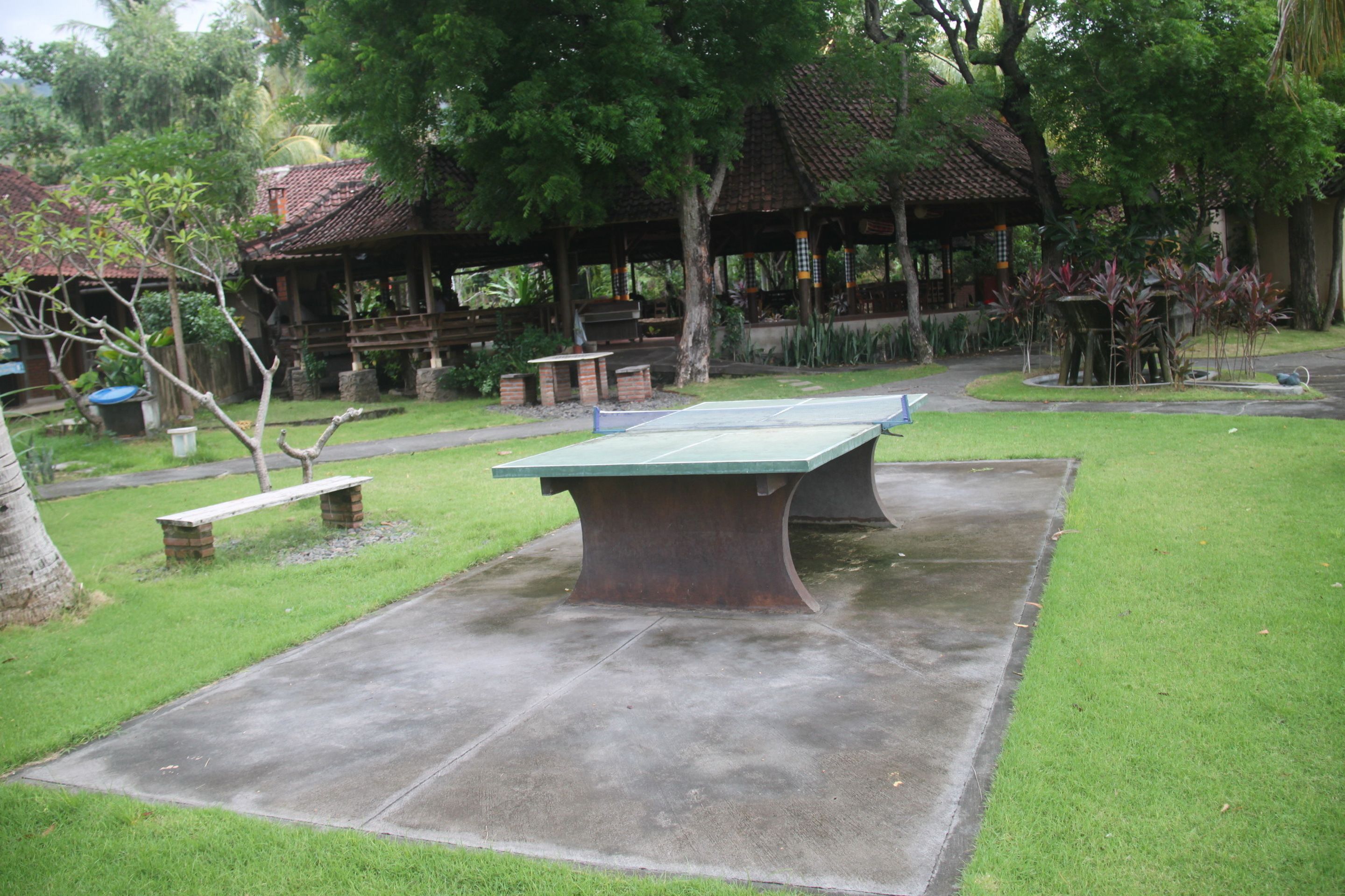 A park with a ping pong table, benches, and a gazebo.