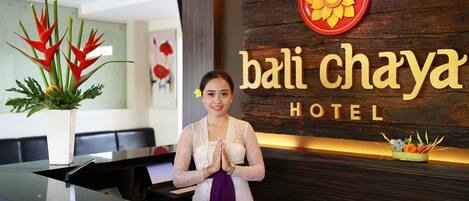 A hotel reception desk with a sign reading "bali chaya hotel".