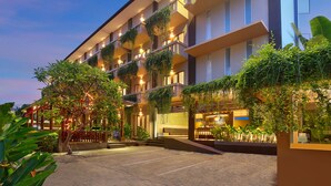 A hotel with multiple balconies, outdoor seating, and lush greenery. - Bali Chaya Hotel Legian (Legian)