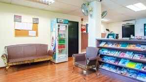 A waiting area with a vending machine, a bookshelf, and a bulletin board. - Vintage Inn @ Clarke Quay - Hostel (Singapore)