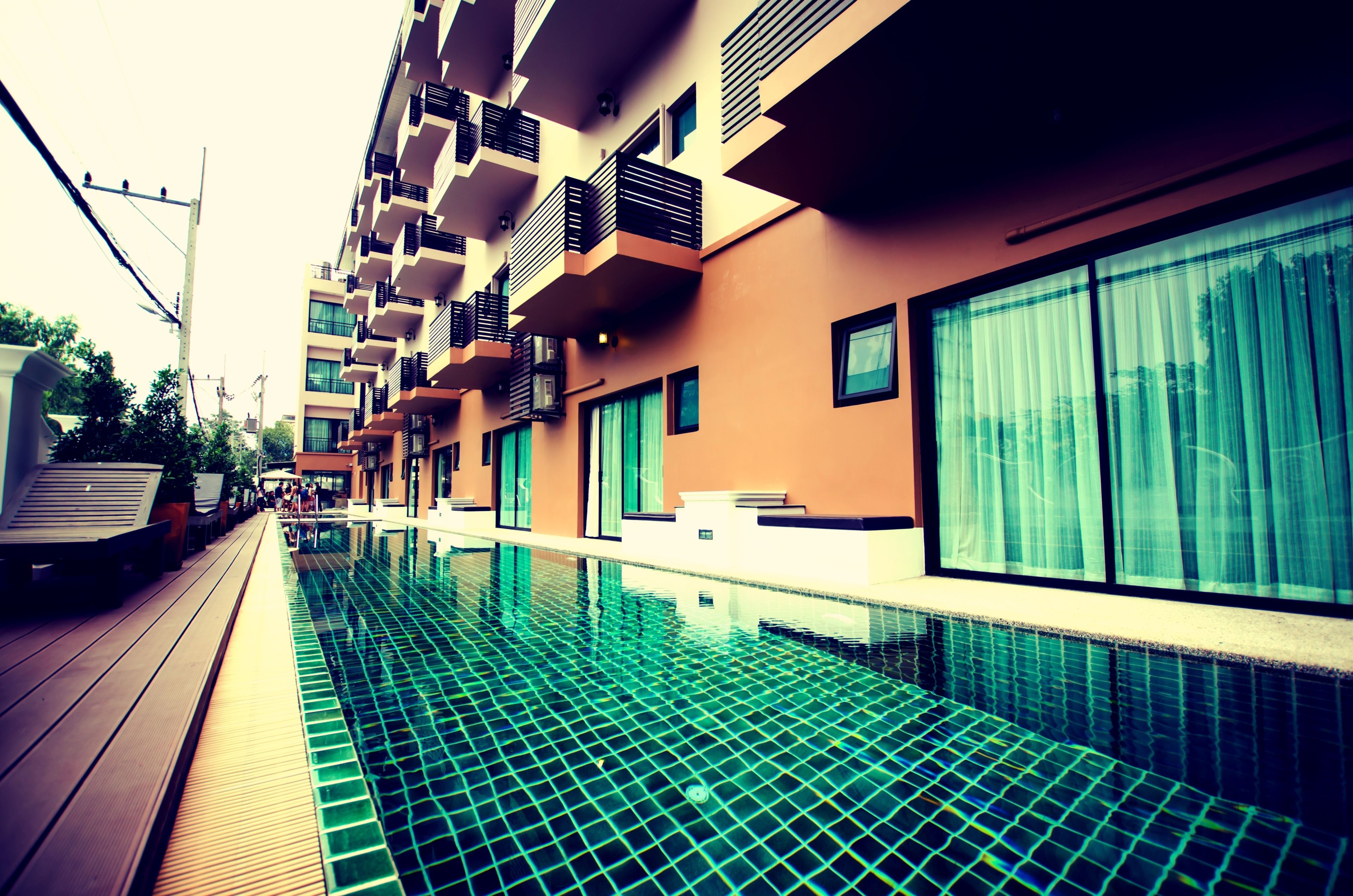 Un hotel moderno con piscina, balcones y ventanas amplias.