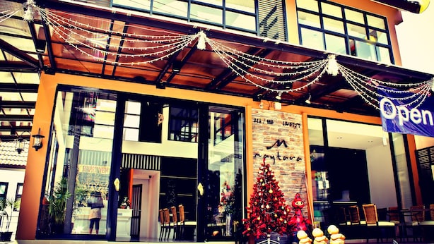 Ein Gebäude mit Glasfassade, einem Weihnachtsbaum und einem Schild mit der Aufschrift 'Open'.