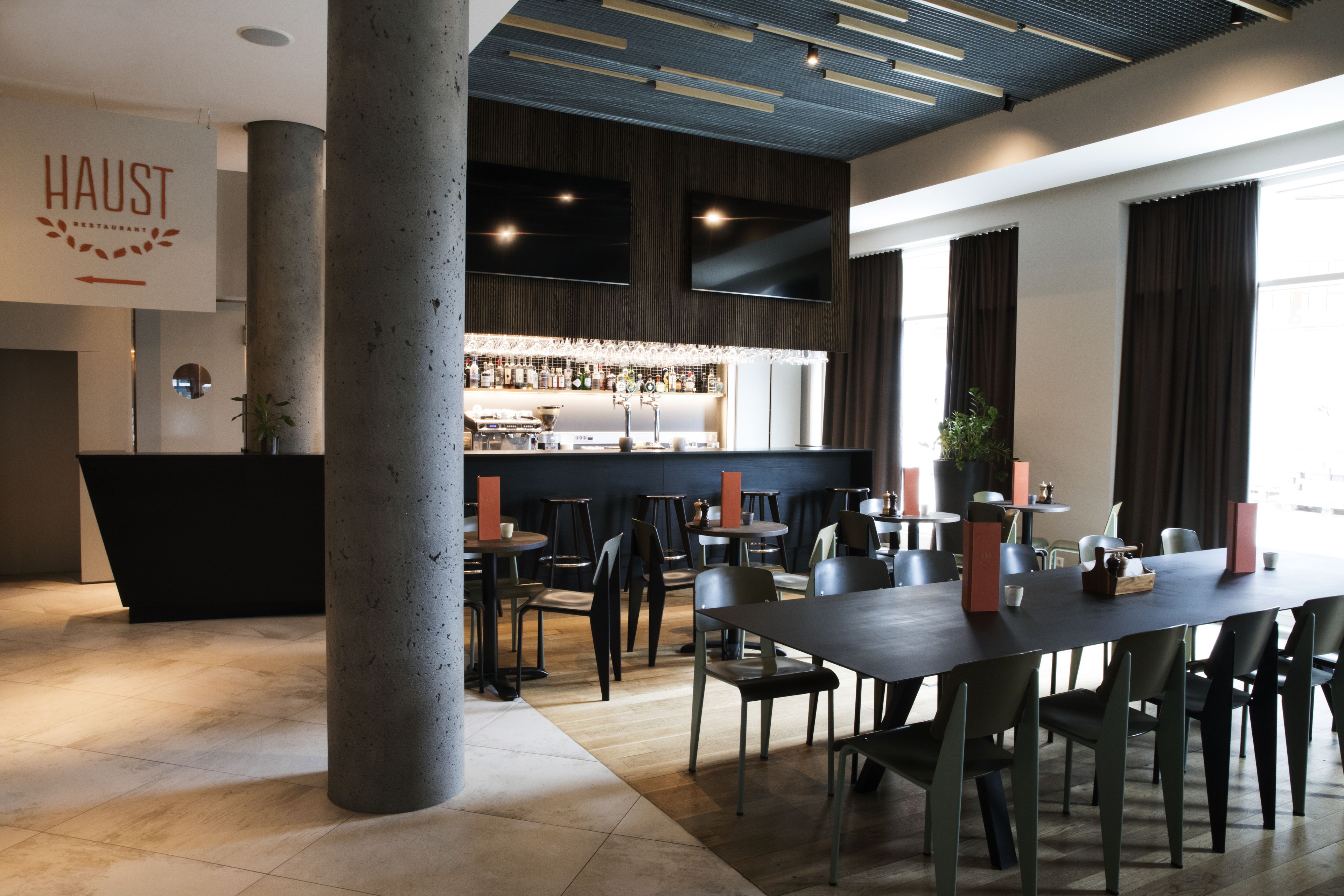 Un interior de restaurante moderno con una barra, mesas y sillas.