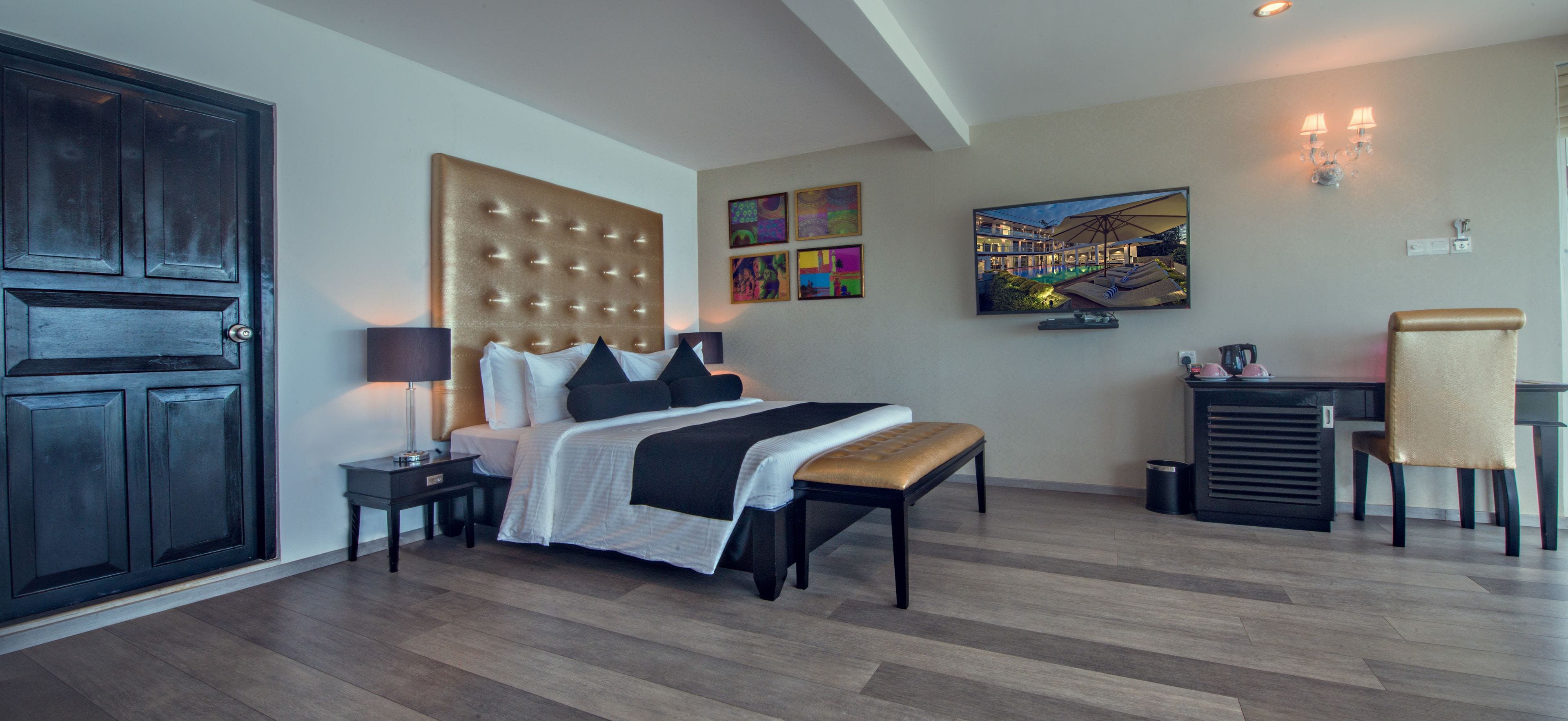 A modern hotel room with a large bed, a desk, and a chair.
