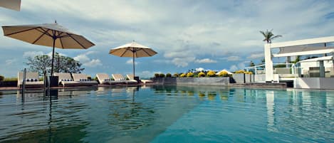 Una piscina al aire libre, sombrillas