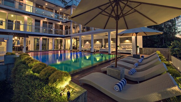 A modern hotel with a pool, lounge chairs, and umbrellas. - Levels Unawatuna (Unawatuna)