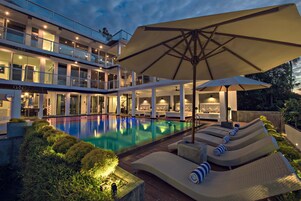 Una piscina al aire libre, sombrillas