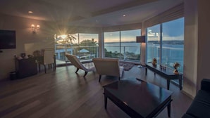 A spacious living room with a large window offering a view of the sea and palm trees. - Levels Unawatuna (Unawatuna)