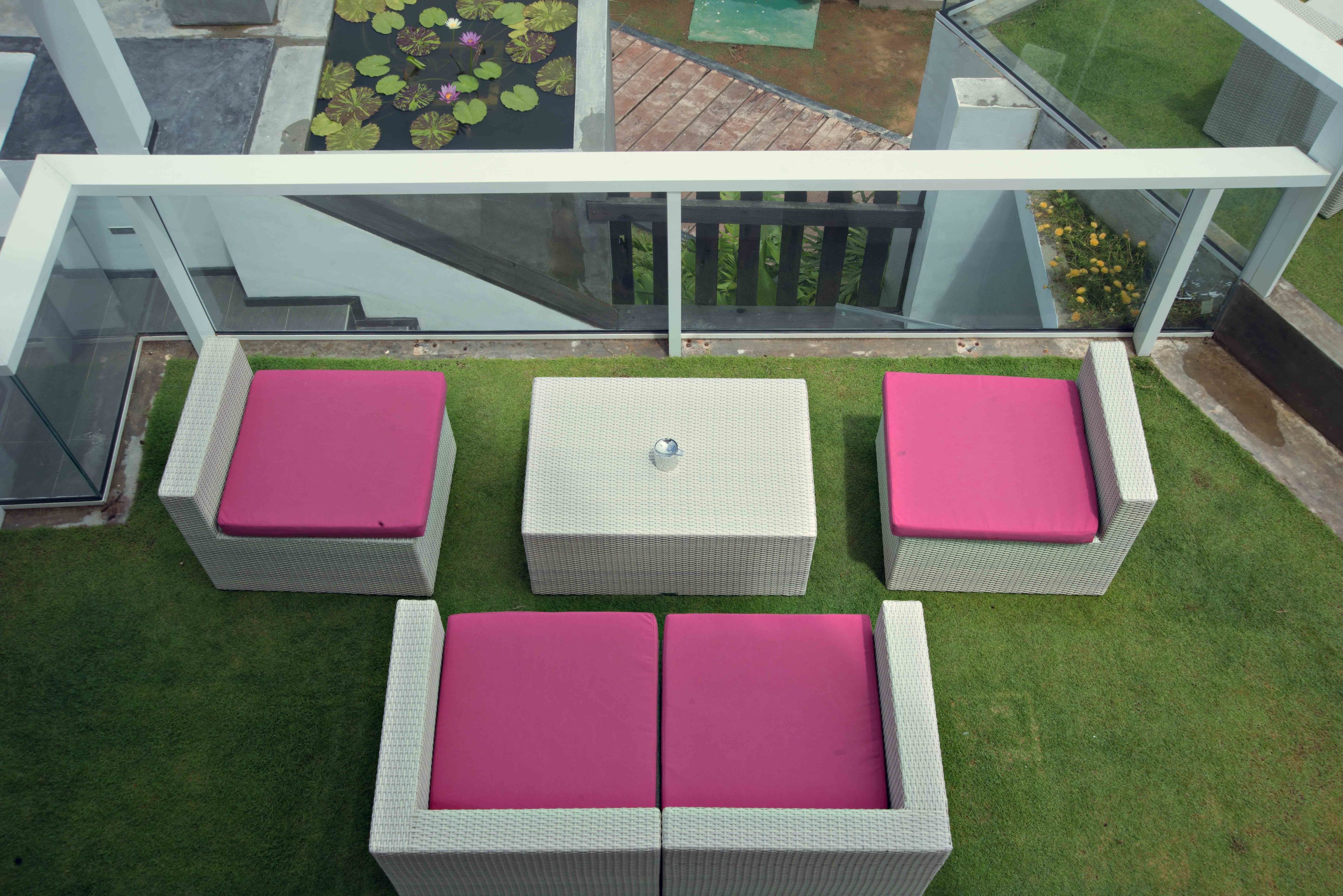 A balcony with wicker furniture and a glass railing.