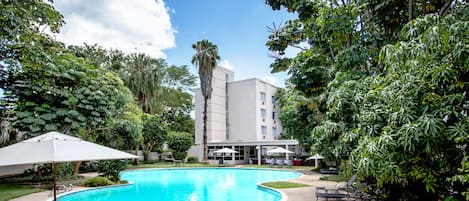 Een buitenzwembad, parasols voor strand/zwembad