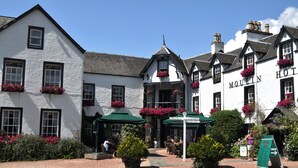 A traditional white building with black trim and multiple windows, featuring a sign that reads "Moulin Hotel." - Moulin Hotel (Pitlochry)