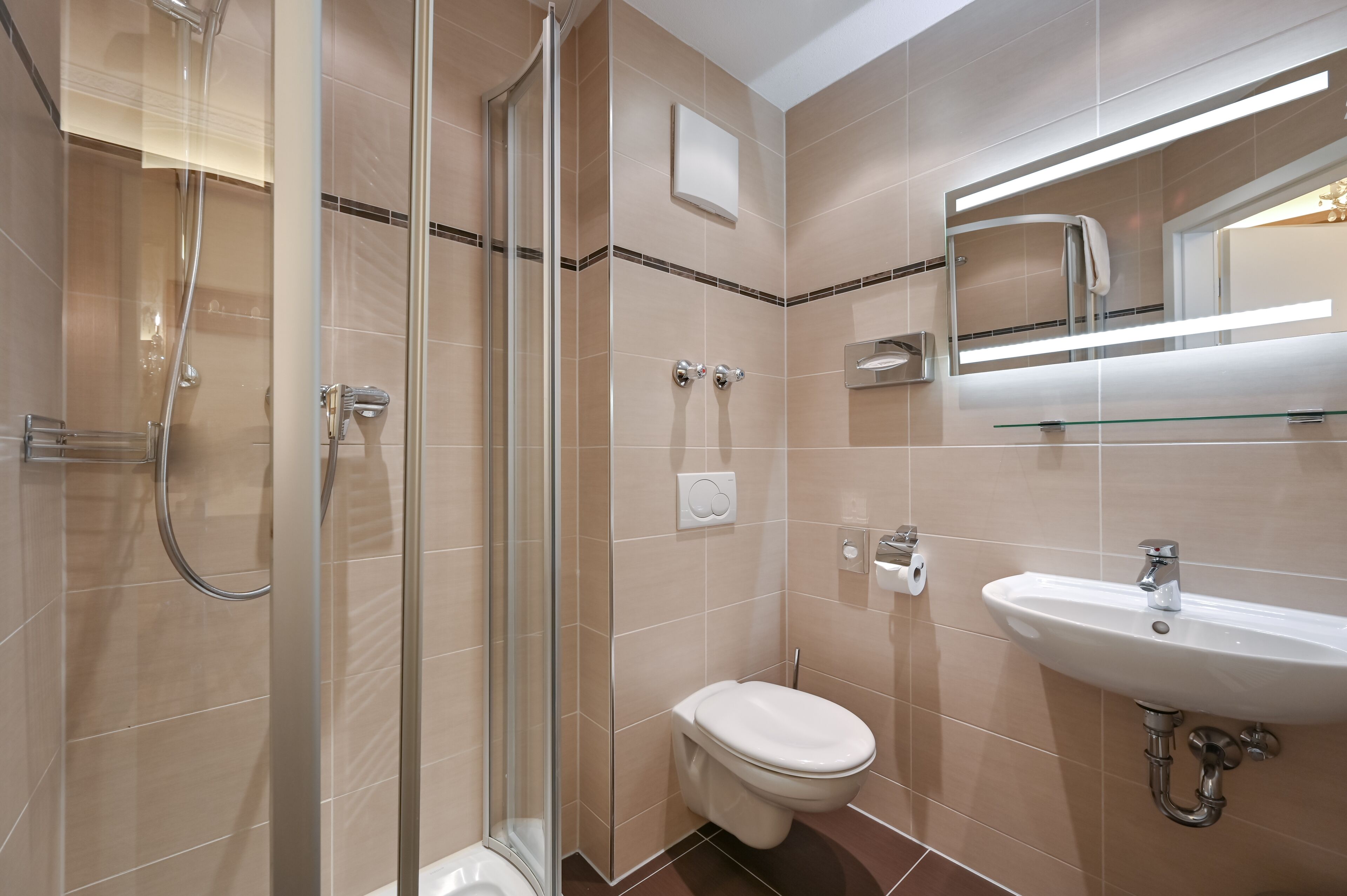 A modern bathroom with a glass-enclosed shower, a toilet, and a sink with a mirror above it.