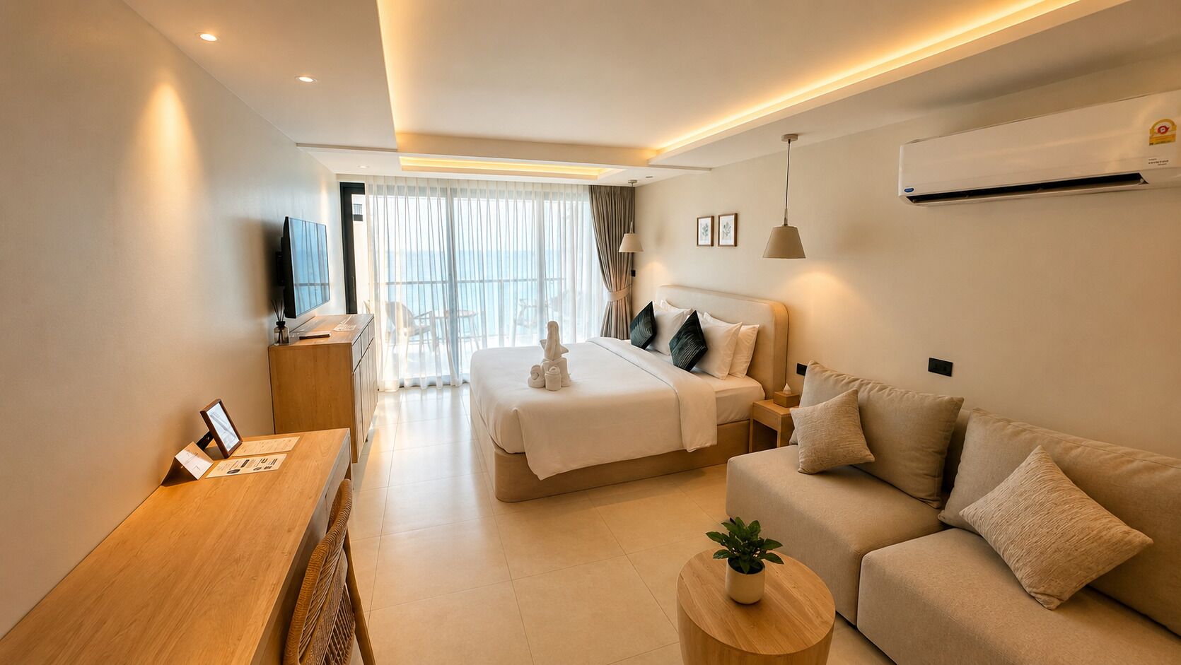 A modern hotel room with a bed, a sofa, a desk, and a TV.