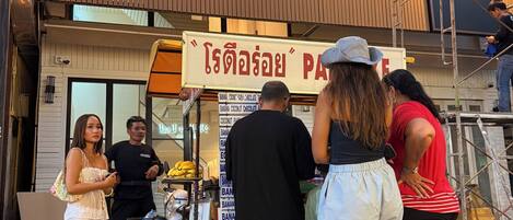 A storefront with a sign reading 'ROZ MARINE BOUTIQUE HOTEL' and a signboard with Thai text.