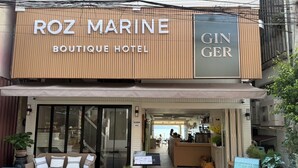 A hotel entrance with a sign for 'ROZ MARINE Boutique Hotel' and a 'GIN GER' sign. - Roz Marine Boutique HOTEL (Koh Samui)