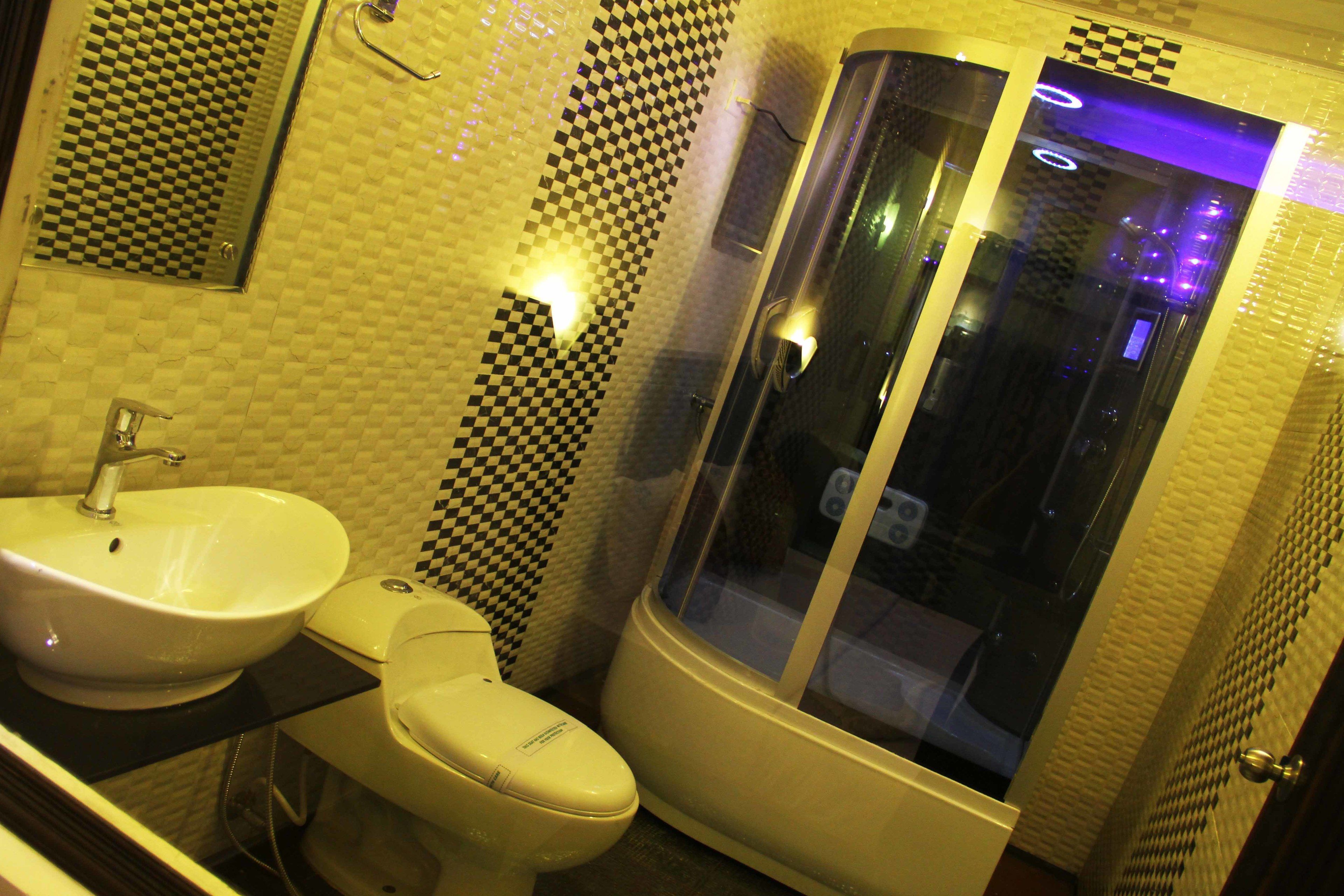 Une salle de bain équipée d’un lavabo, de toilettes et d’une douche à parois de verre.