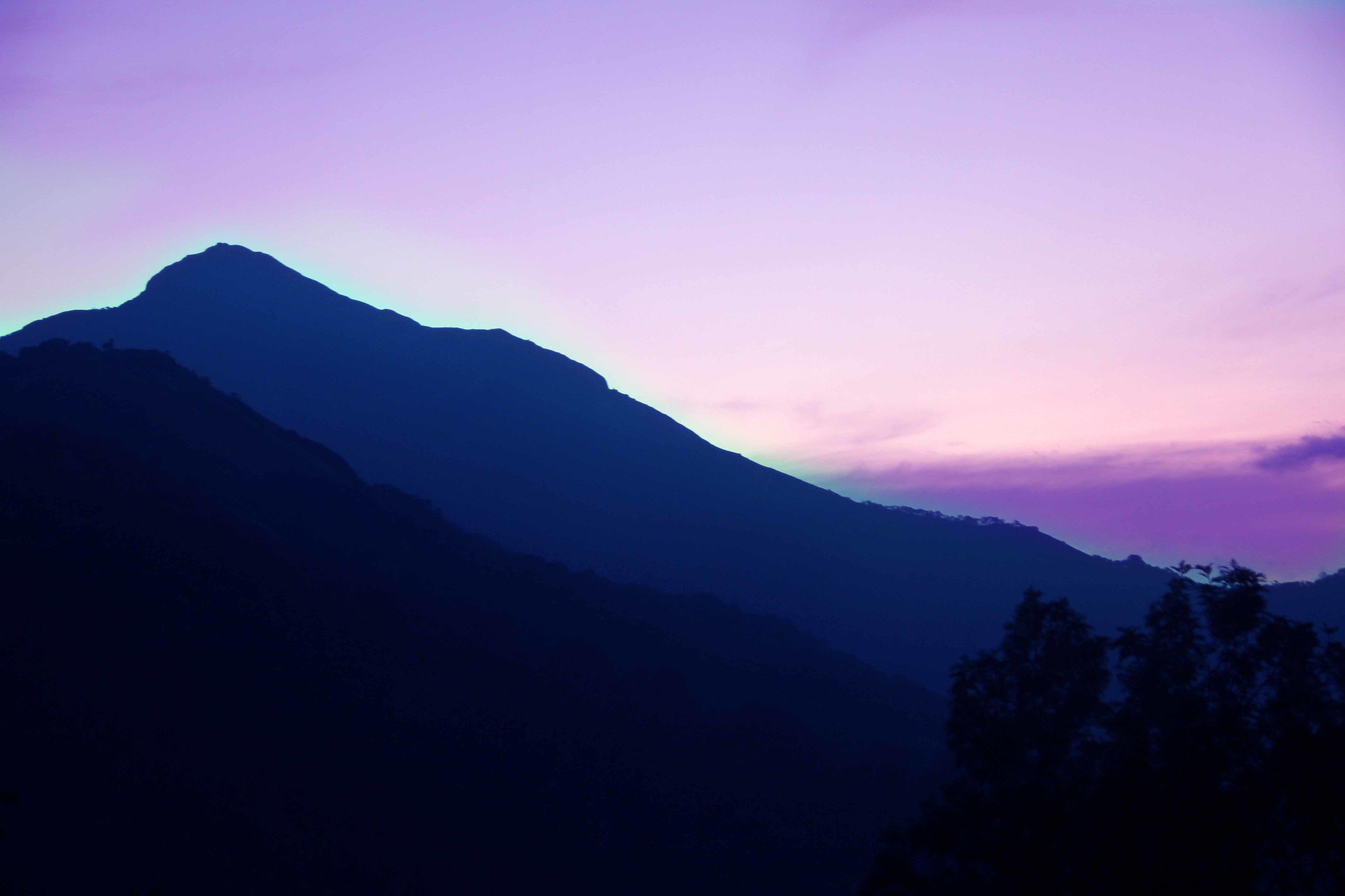 A mountain silhouette against a twilight sky.