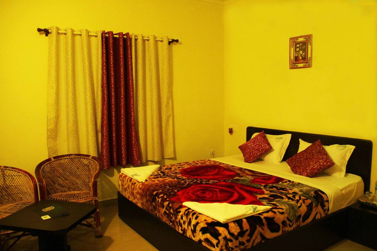 Una habitación de hotel con una cama, una silla, una mesa y cortinas.