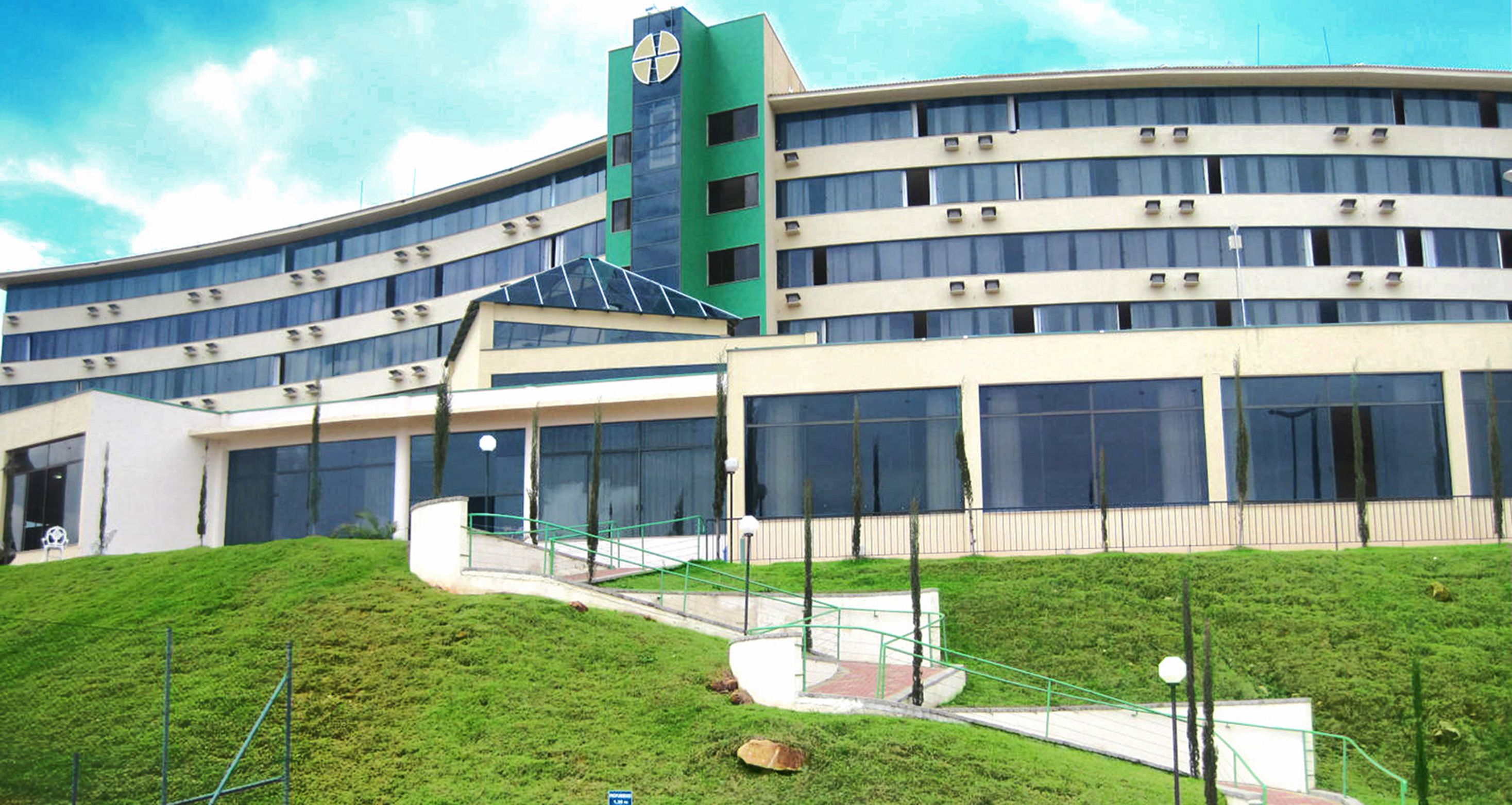 A modern building with a curved facade, multiple windows, and a central tower.
