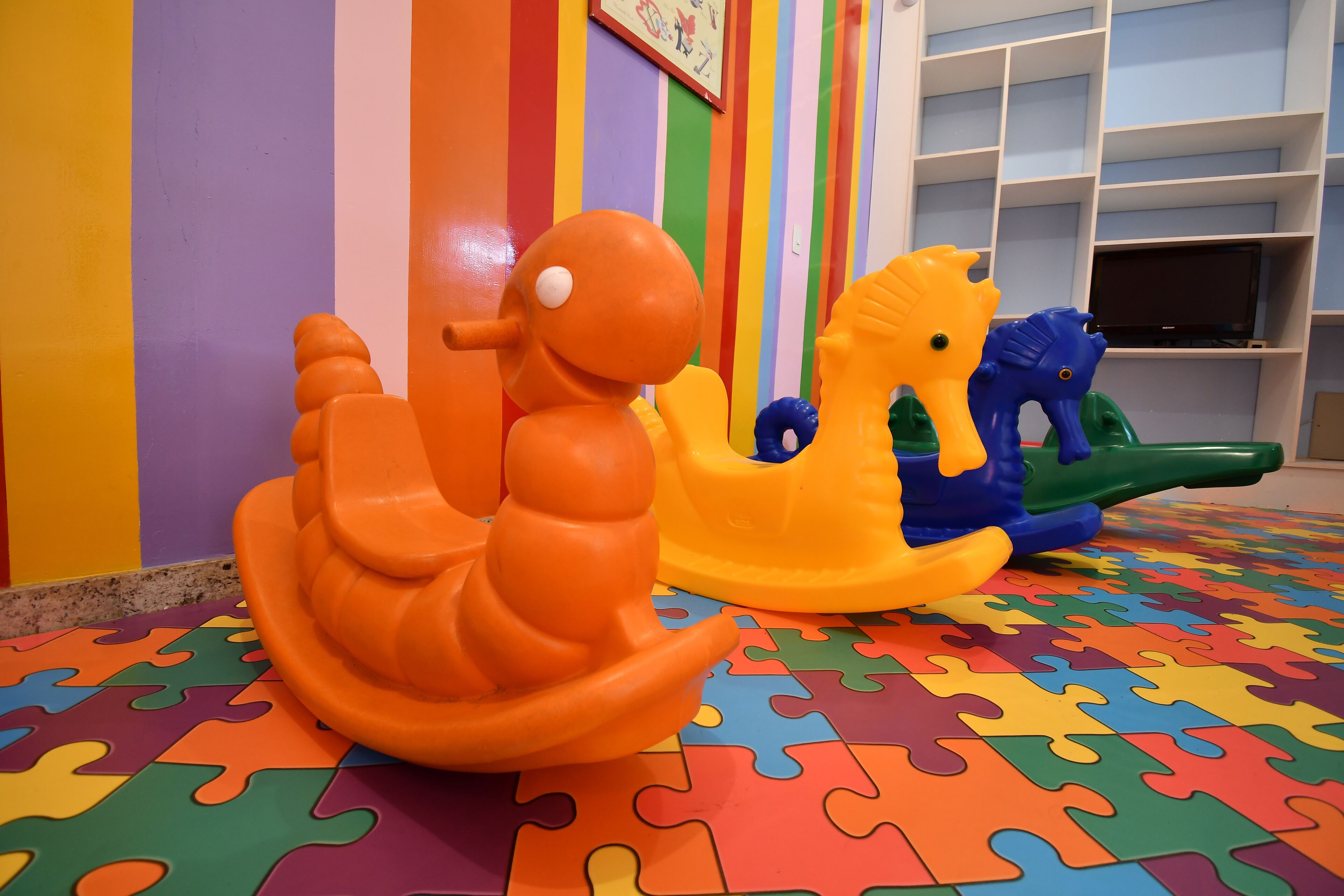 A colorful play area with a puzzle floor and two toy boats.
