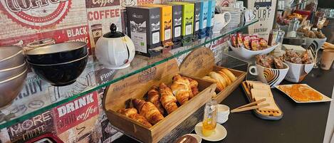 Mostrador de una cafetería con diversos productos de café, pasteles y opciones para el desayuno.