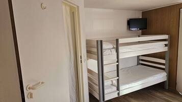 A bunk bed room with a television mounted above it.