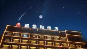 A hotel building with illuminated signage and multiple floors. - Yiaihu Hotel (Huanggang)