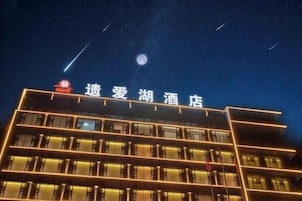 Un hotel con un letrero en caracteres chinos, varios pisos y un cielo estrellado.