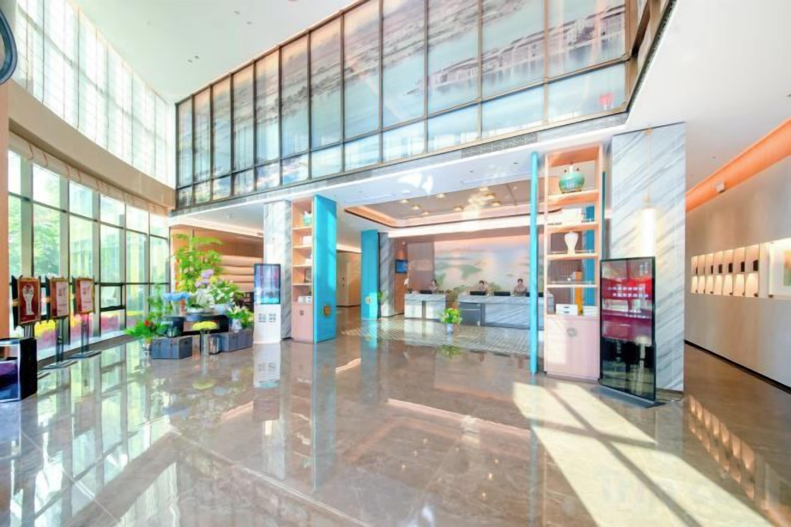 A spacious lobby with a high ceiling, a reception desk, and a glass storefront.