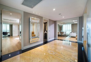 A spacious hotel lobby with a marble floor, large mirrors, and a modern interior design.