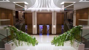 A modern hotel lobby with a central staircase, glass railings, and decorative plants. - Radisson Blu Hotel, Kayseri (Kayseri)