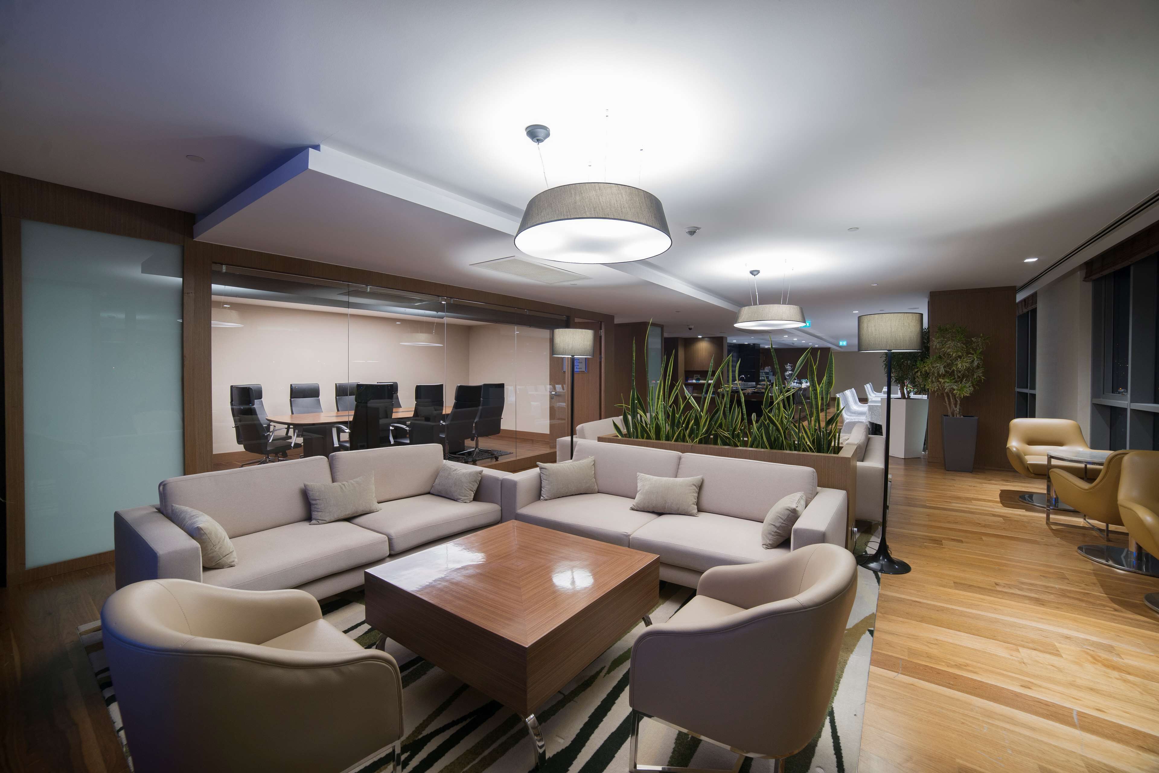 Un vestíbulo moderno con un sofá modular, una mesa de centro y una recepción.
