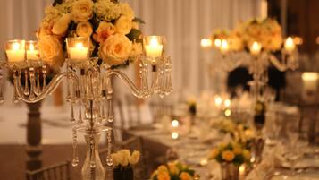 A table set for a formal event with candelabras, candles, and floral centerpieces.