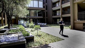 Un bâtiment moderne à plusieurs étages, doté d’une terrasse et d’un espace jardin aménagé.