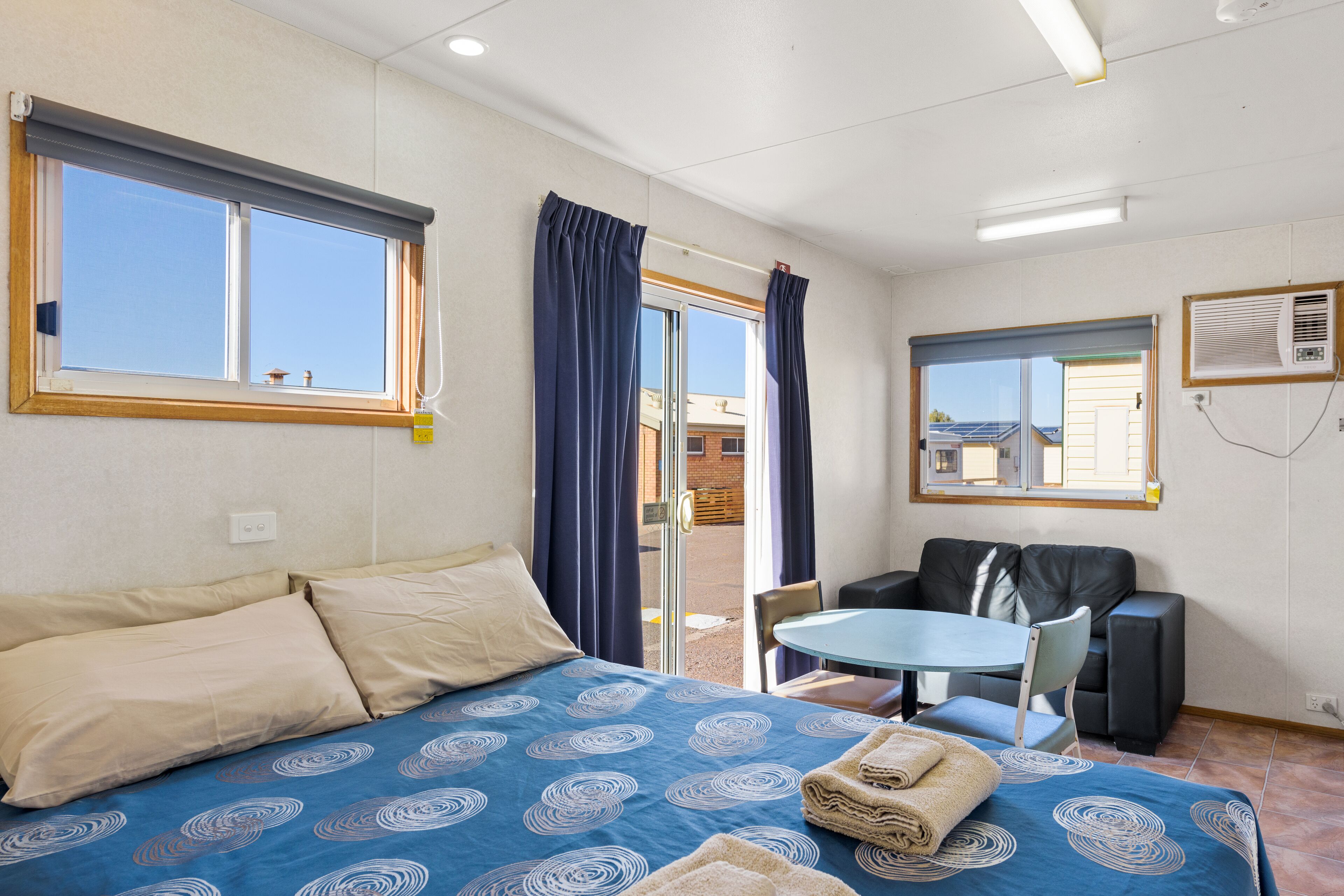 A room with a bed, a table, a chair, and a window.