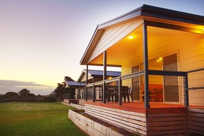 A modern house with a covered porch, a well-maintained lawn, and a clear sky.