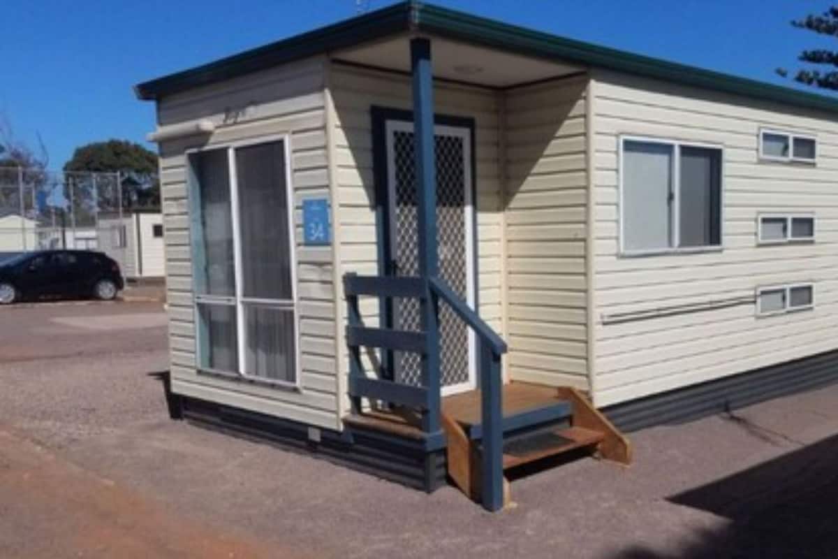 A single-story mobile home with a front porch and a small staircase leading to the entrance.